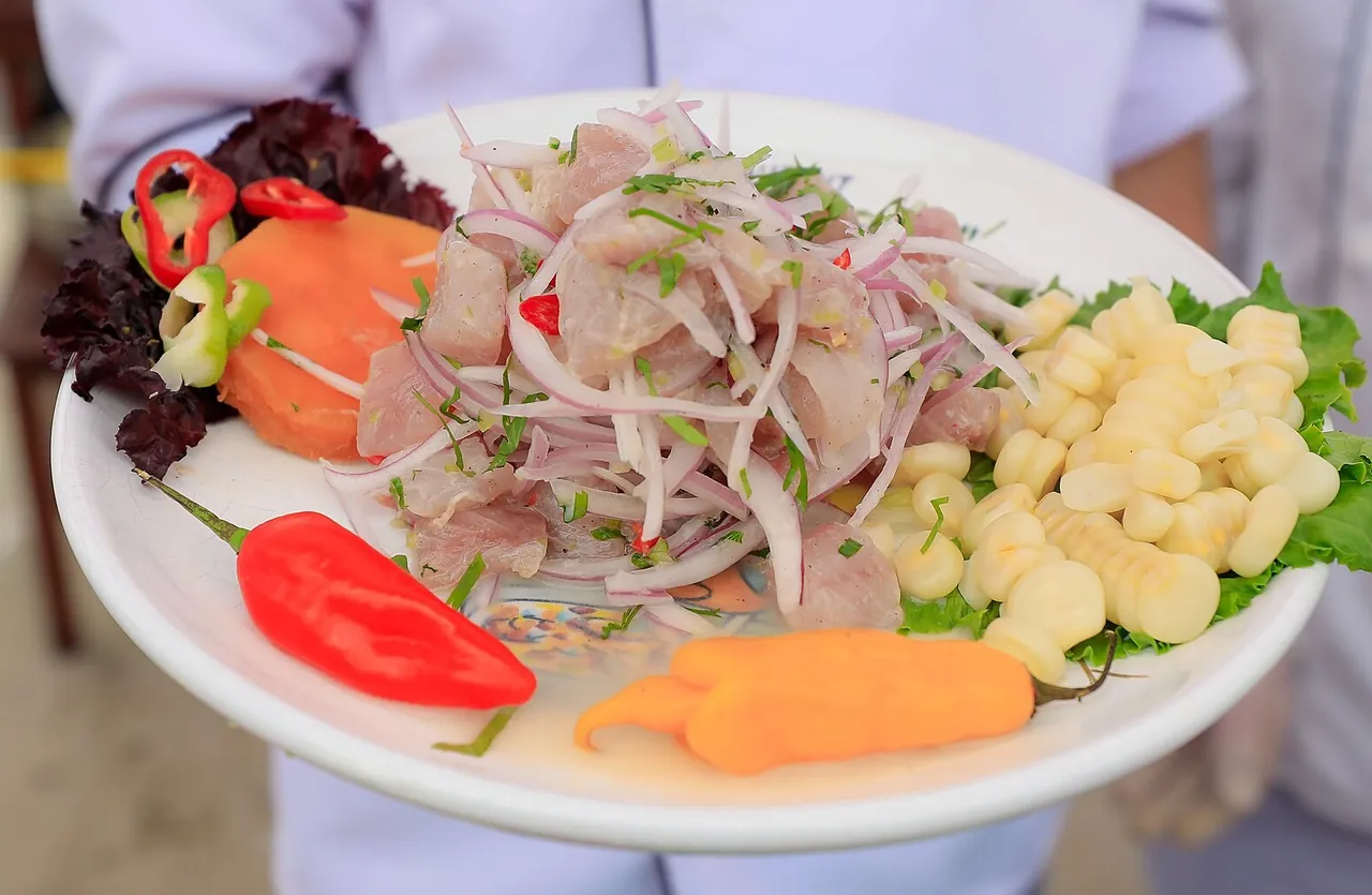 Cebiche de pescado con cebolla roja, camote, choclo, ají y lechuga